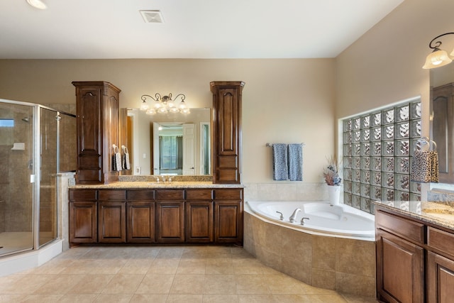 bathroom with plus walk in shower, vanity, and tile patterned flooring