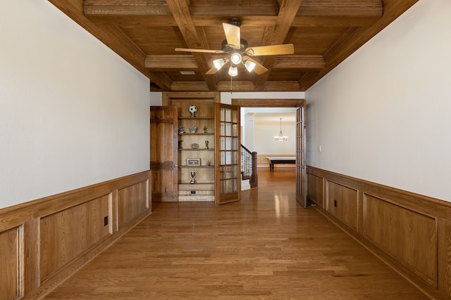 hallway featuring coffered ceiling, wooden ceiling, beamed ceiling, hardwood / wood-style floors, and a chandelier