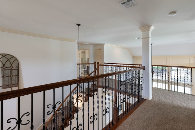 hallway with carpet flooring, vaulted ceiling, crown molding, and ornate columns