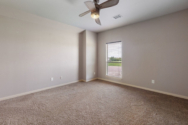 unfurnished room with ceiling fan and carpet