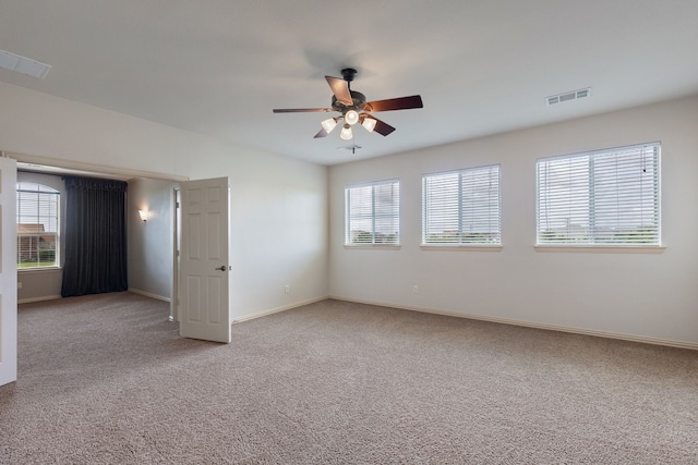 carpeted spare room with ceiling fan