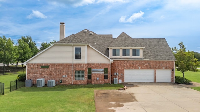 view of front of house featuring central AC unit, a garage, and a front lawn