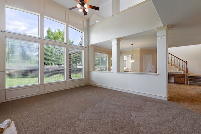 carpeted spare room featuring ceiling fan, a healthy amount of sunlight, ornamental molding, and high vaulted ceiling