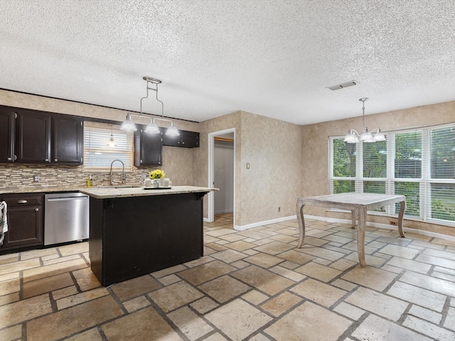 kitchen featuring pendant lighting, dishwasher, an inviting chandelier, dark brown cabinetry, and a kitchen island