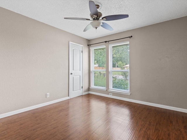 spare room with ceiling fan, dark wood-type flooring, and a textured ceiling