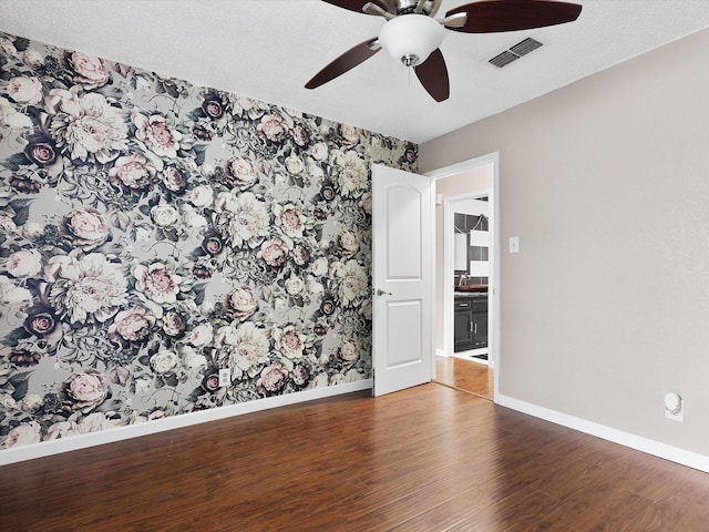 spare room featuring wood-type flooring and a textured ceiling