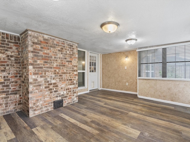 empty room featuring dark hardwood / wood-style floors and a textured ceiling