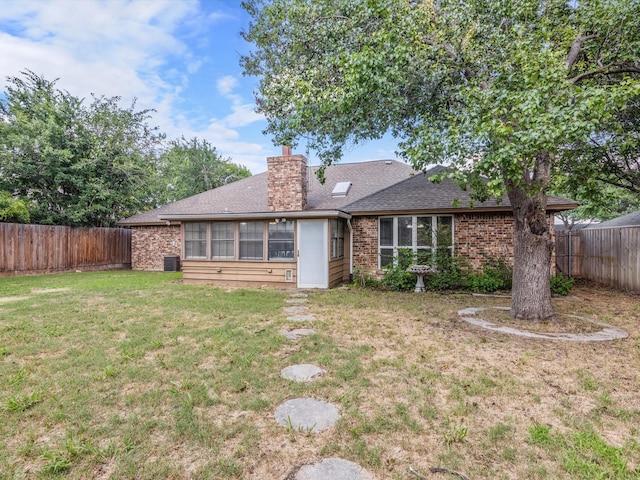 back of house with a yard and central AC unit