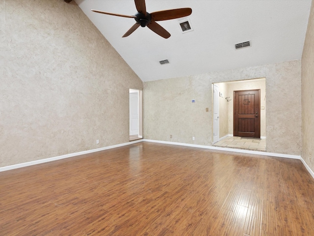 spare room with hardwood / wood-style flooring, high vaulted ceiling, and ceiling fan