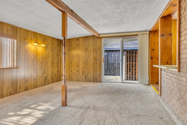 unfurnished room featuring wood walls, ceiling fan, and light colored carpet