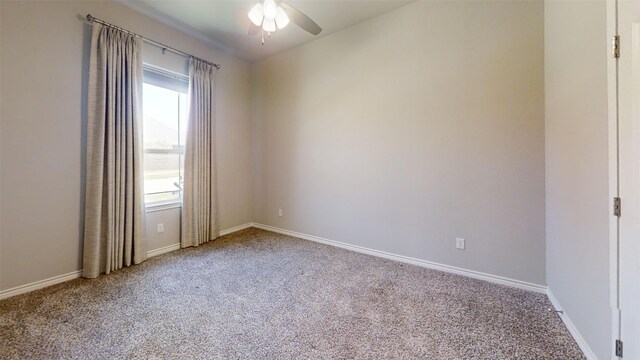 carpeted empty room with baseboards and ceiling fan