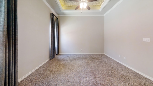 carpeted spare room featuring ceiling fan, a raised ceiling, and crown molding