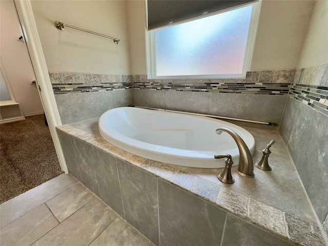 bathroom featuring a relaxing tiled bath and tile floors