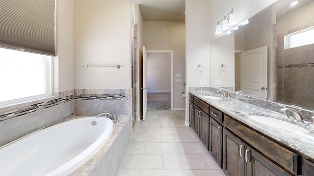 bathroom featuring tile floors, tiled bath, and double vanity