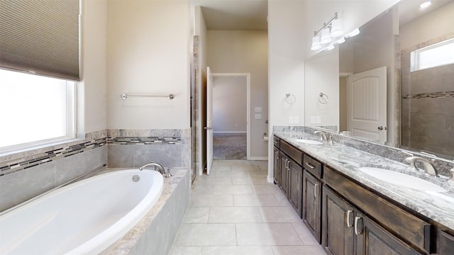 full bath featuring a bath, tile patterned flooring, a sink, and double vanity