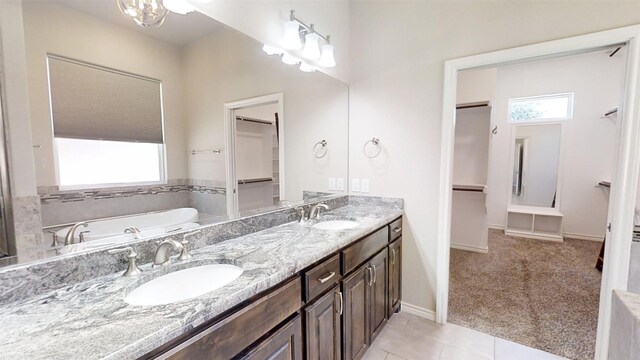 bathroom with dual vanity, tile floors, and a bathtub