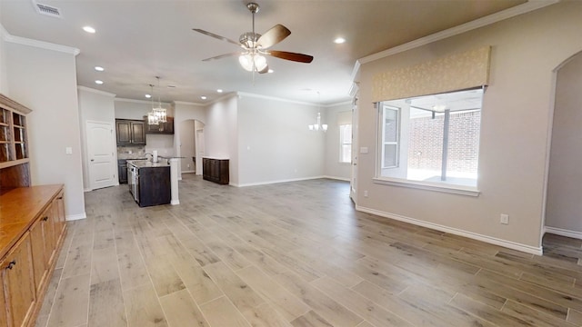 unfurnished living room with ceiling fan with notable chandelier, light hardwood / wood-style flooring, sink, and ornamental molding