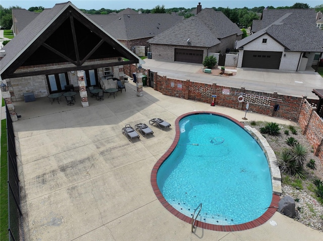 community pool featuring a fenced backyard and a patio