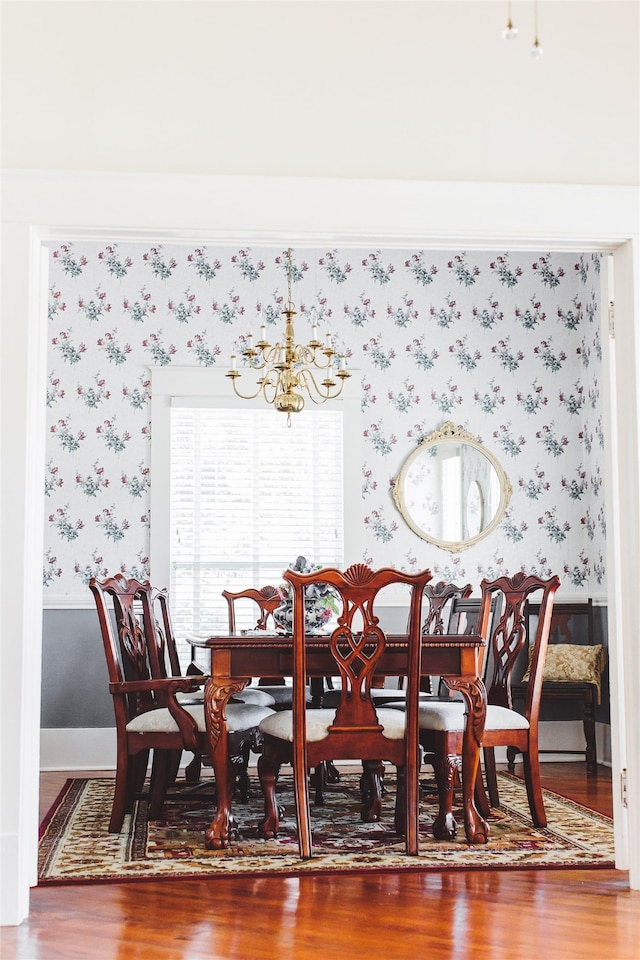 dining room featuring wood-type flooring and an inviting chandelier