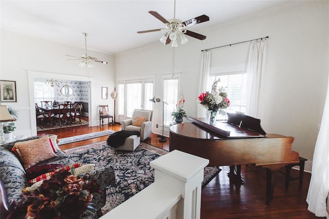 living room with dark wood-type flooring, crown molding, and a healthy amount of sunlight