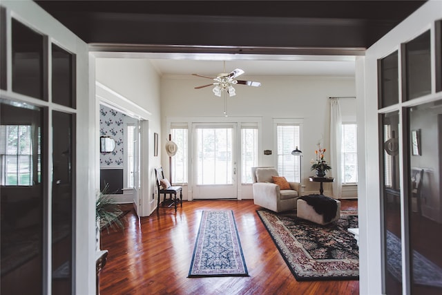 living room featuring hardwood / wood-style flooring, ceiling fan, and crown molding