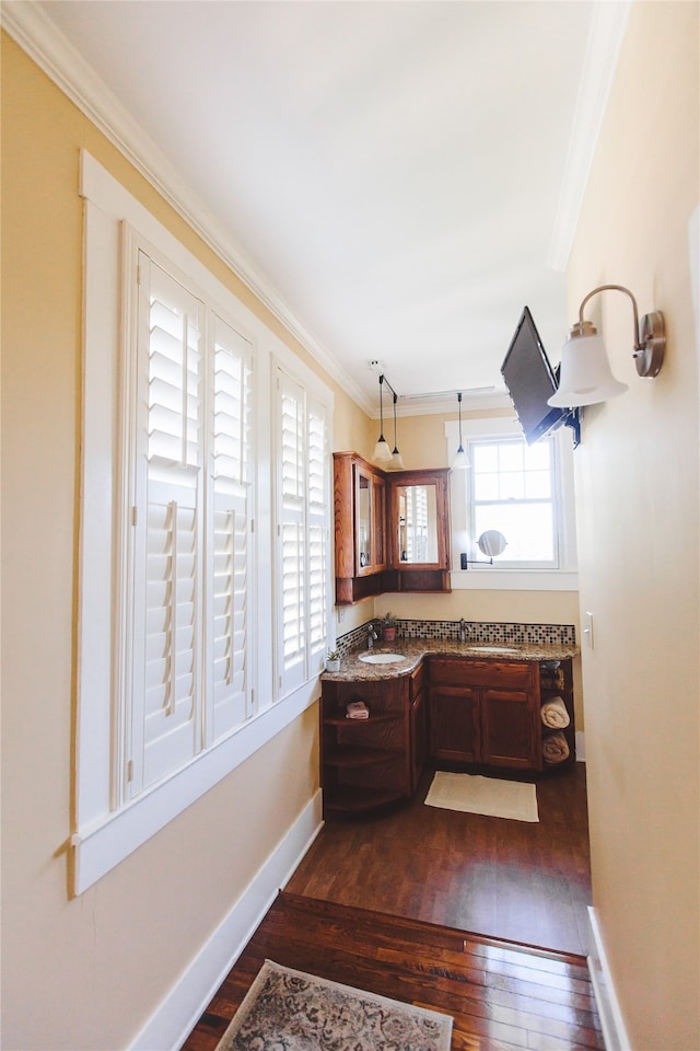 interior space with crown molding, vanity, and hardwood / wood-style flooring