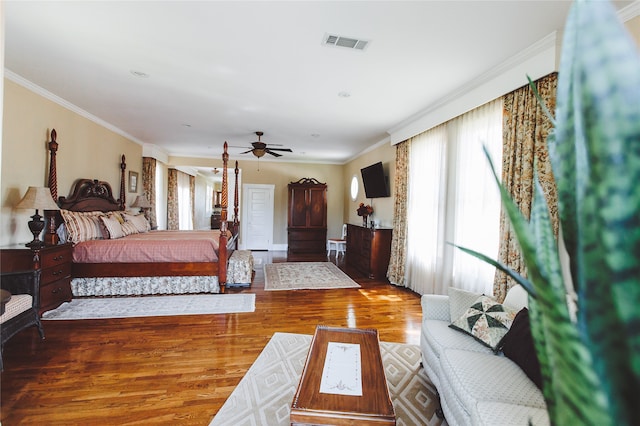 bedroom with hardwood / wood-style flooring, ceiling fan, and crown molding