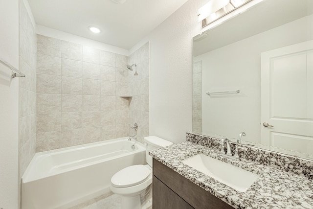 full bathroom featuring vanity, tiled shower / bath combo, and toilet