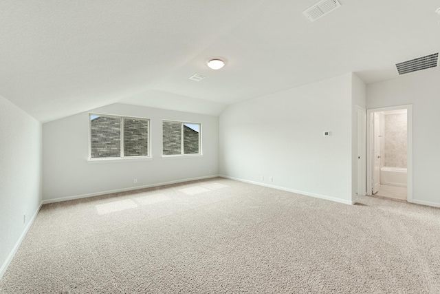 bonus room with light carpet and lofted ceiling