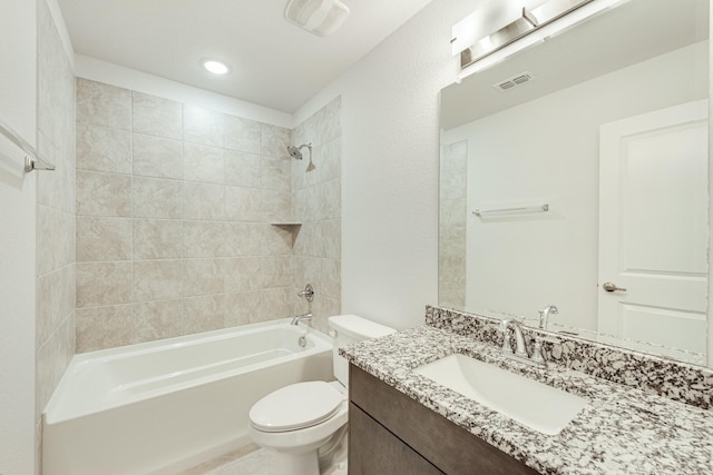 full bathroom featuring tiled shower / bath combo, toilet, and vanity