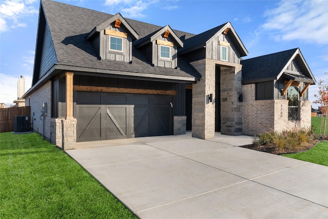 view of front of house featuring a garage, a front yard, and central AC unit