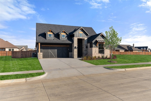 view of front of property with a garage, a front yard, and central air condition unit