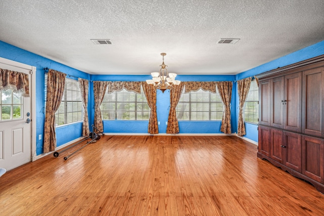 unfurnished dining area with a wealth of natural light, light wood-type flooring, and visible vents