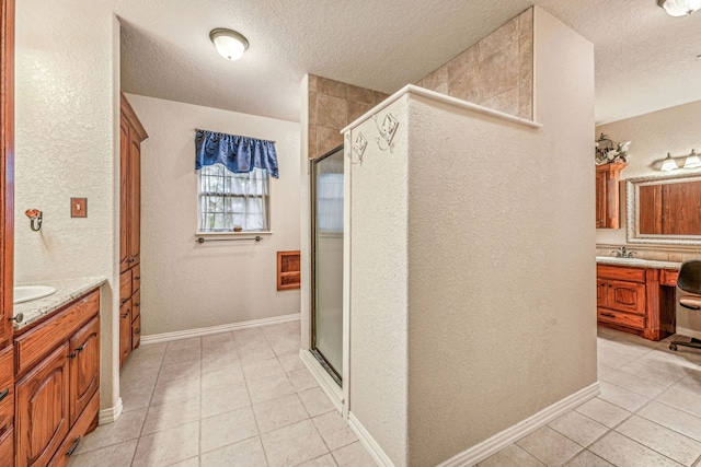 bathroom featuring a sink, two vanities, a shower stall, and tile patterned flooring