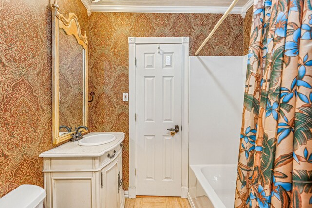 full bathroom with crown molding, shower / bathtub combination with curtain, toilet, and vanity