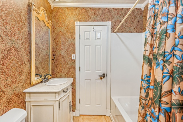 bathroom featuring crown molding, toilet, shower / tub combo, vanity, and wallpapered walls