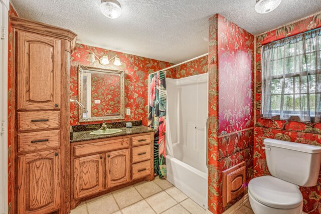 full bathroom with vanity, tile patterned floors, shower / bath combo with shower curtain, toilet, and a textured ceiling