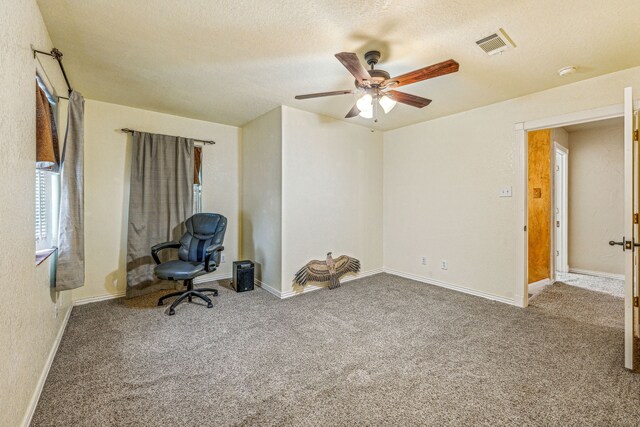 unfurnished office with carpet, a textured ceiling, and ceiling fan