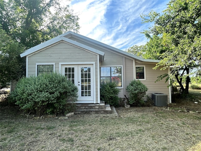 back of property featuring cooling unit and a yard