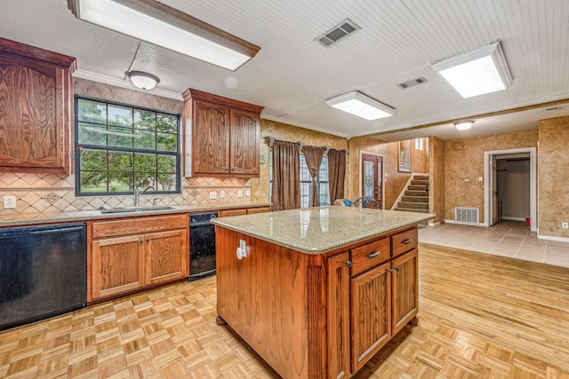 kitchen featuring black dishwasher, sink, light parquet floors, and a center island