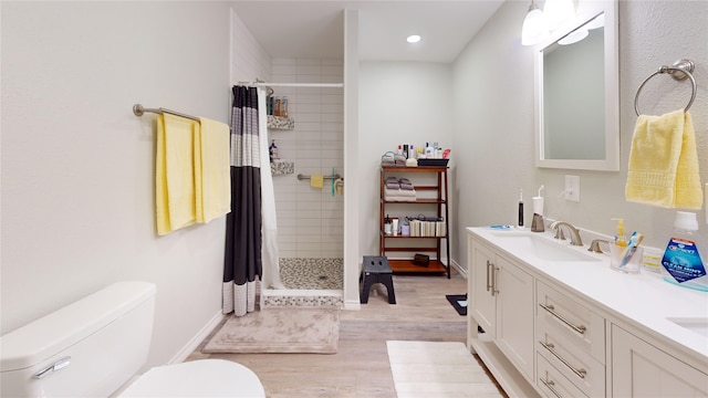 bathroom featuring vanity, hardwood / wood-style flooring, toilet, and curtained shower