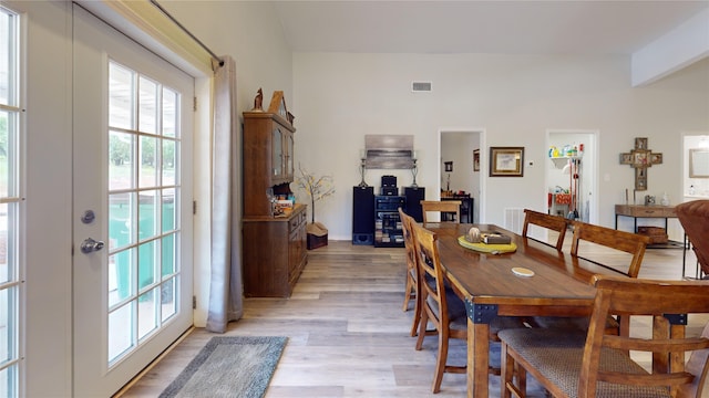 dining space with light hardwood / wood-style floors and french doors