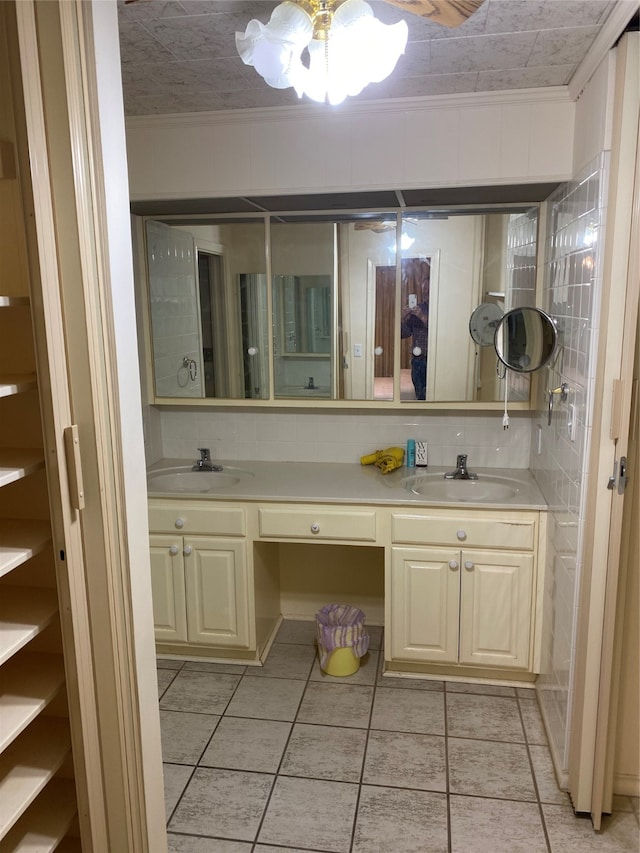 bathroom featuring dual vanity, ceiling fan, ornamental molding, and backsplash