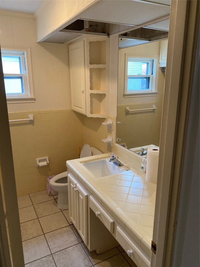 bathroom featuring tile walls, toilet, tile floors, ornamental molding, and vanity