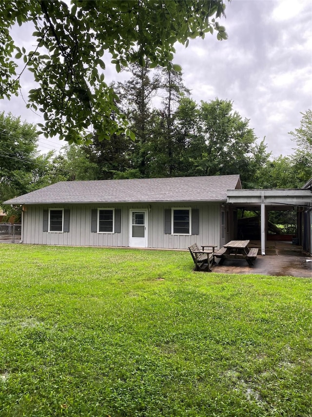 view of front of property with a front lawn, a carport, and board and batten siding