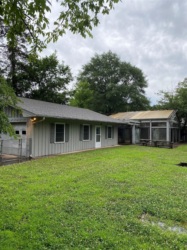 back of house featuring a sunroom and a yard