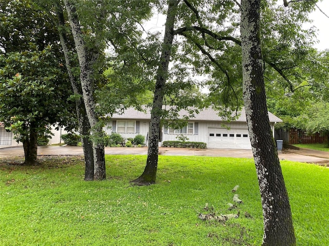 view of front of property with a front lawn, board and batten siding, concrete driveway, and an attached garage