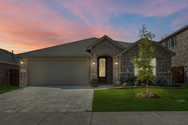 view of front of home with a garage and a yard