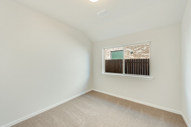 empty room featuring carpet floors and vaulted ceiling