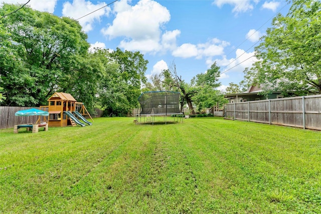 view of yard with a trampoline and a playground